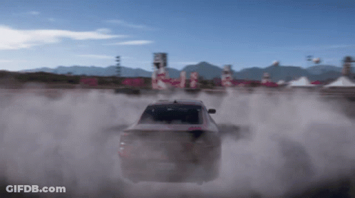A Car Is Driving On A Dirt Road With Smoke Coming Out Of The Back GIF