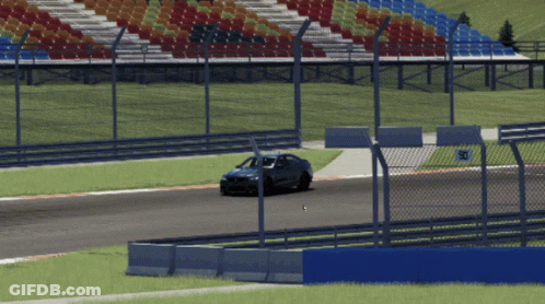 A Car Is Driving On A Race Track With A Fence And A Sign That Says 30 GIF