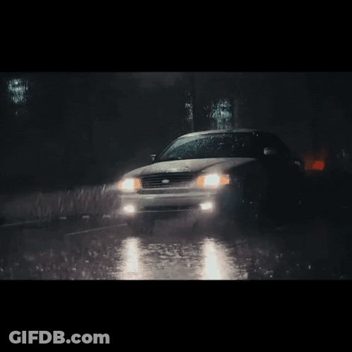 A Car Is Driving Through The Rain At Night GIF
