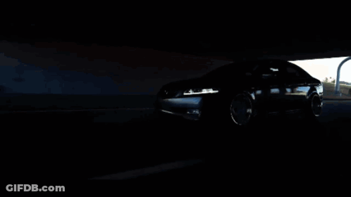 A Car Is Driving Under A Bridge In The Dark GIF