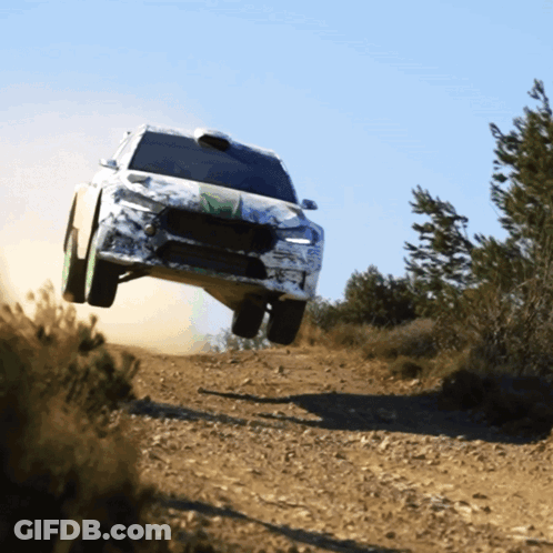 A Car Is Flying Through The Air On A Dirt Track GIF