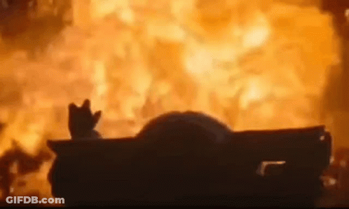 A Car Is On Fire With A Hand Sticking Out Of The Window . GIF