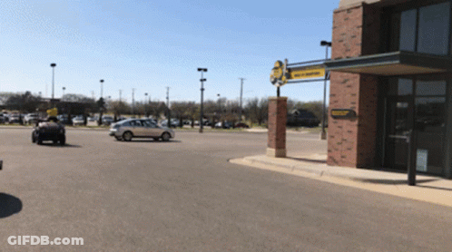 A Car Is Parked In Front Of A Building That Has A Yellow Sign That Says ' Tractor Supply Company ' On It GIF