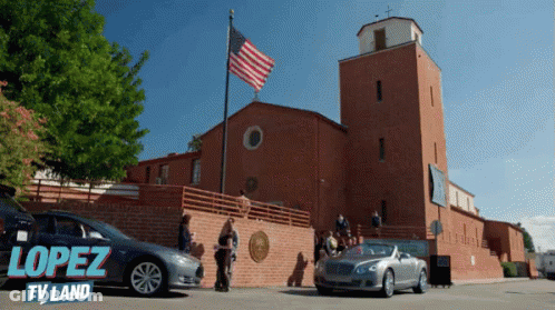 A Car Is Parked In Front Of A Building That Says Lopez Tv Land On The Bottom GIF