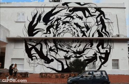 A Car Is Parked In Front Of A Building With A Large Painting On It GIF