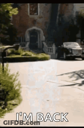 A Car Is Parked In Front Of A House With The Words I 'M Back Written On The Sidewalk . GIF