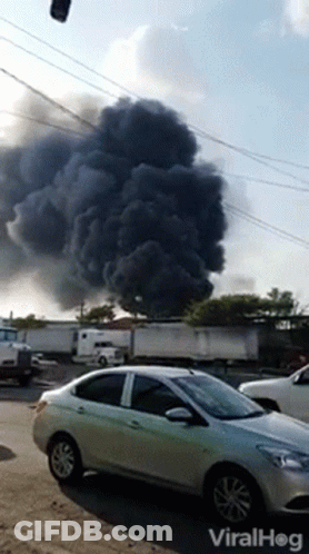 A Car Is Parked In Front Of A Large Cloud Of Smoke And The Words Viralhog Are On The Bottom Of The Screen GIF