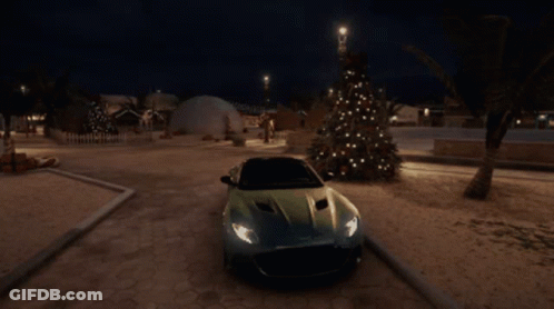 A Car Is Parked Next To A Christmas Tree At Night GIF