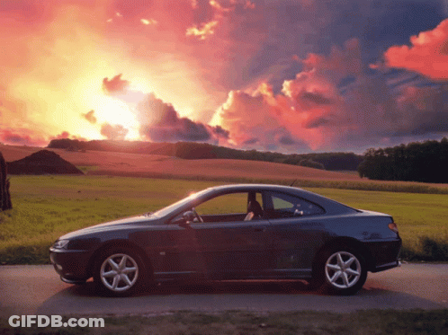 A Car Is Parked On The Side Of A Road In Front Of A Sunset GIF