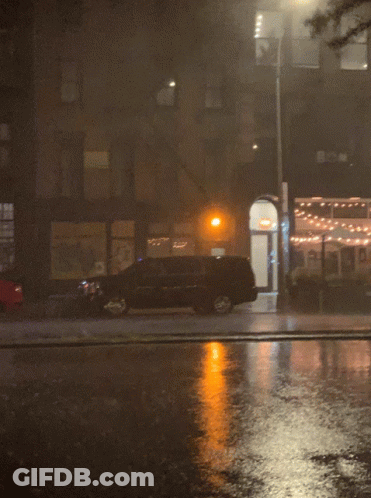A Car Is Parked On The Side Of The Road In Front Of A Building GIF