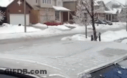 A Car Is Parked On The Side Of The Road In Front Of A Snow Covered Street . GIF