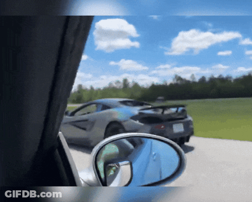 A Car Is Parked On The Side Of The Road With A Rear View Mirror GIF