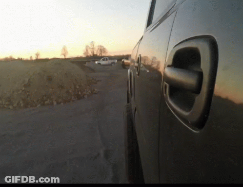 A Car Is Parked On The Side Of The Road With A Sunset In The Background GIF