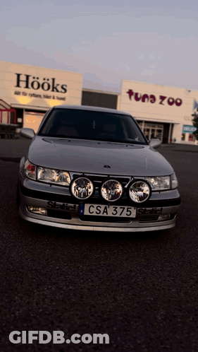 A Car With A License Plate That Says Csa 375 Is Parked In Front Of A Store Called Hooks GIF