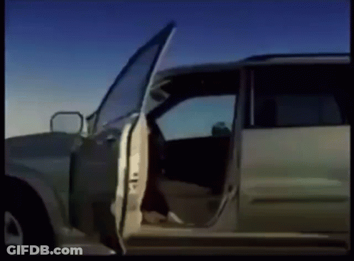 A Car With Its Doors Open Is Parked On A Dirt Road GIF