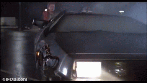 A Car With The Headlights On Is Driving Down A Dark Street GIF