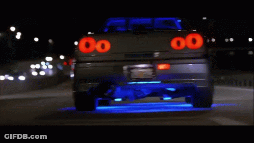 A Car With The Number 00 On The Back Is Driving Down The Road GIF