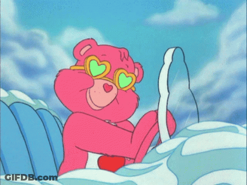 A Care Bear Wearing Heart Shaped Sunglasses Is Sitting On A Wave GIF