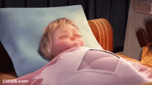 A Cartoon Baby Is Sleeping On A Bed With A Blue Pillow And A Pink Blanket GIF