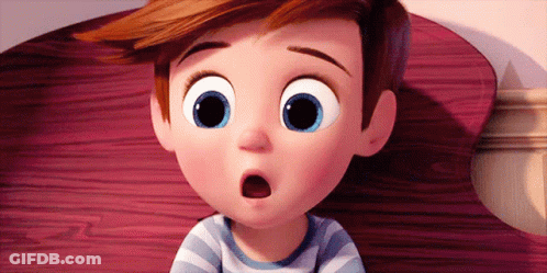 A Cartoon Boy With Big Blue Eyes Is Sitting On A Bed With His Mouth Open . GIF