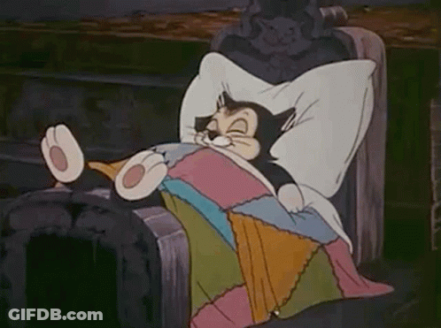 A Cartoon Cat Is Laying In A Bed With A Blanket And Pillow . GIF