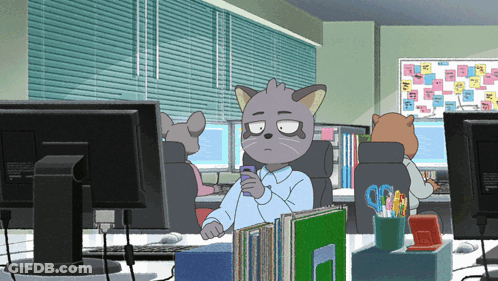 A Cartoon Cat Is Sitting At A Desk With A Cell Phone In His Hand GIF