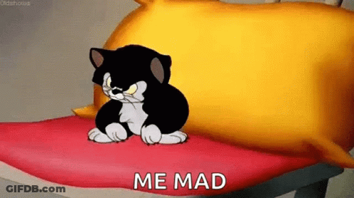 A Cartoon Cat Is Sitting On A Bed With The Words `` Me Mad '' Written On The Bottom . GIF