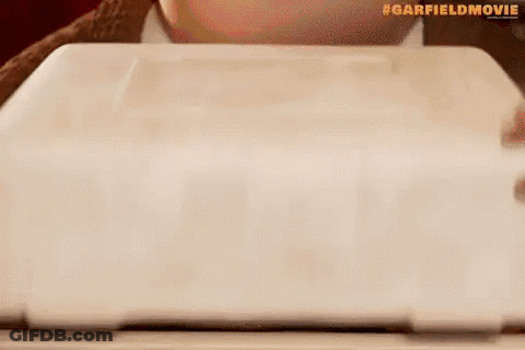 A Cartoon Cat Is Sitting On Top Of A Plate Of Lasagna . GIF