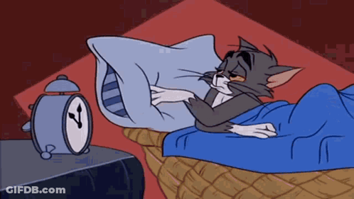 A Cartoon Cat Is Sleeping In A Bed Next To An Alarm Clock GIF