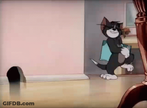 A Cartoon Cat Is Standing In A Room With A Mouse Hole In The Floor . GIF