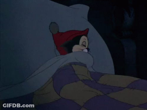 A Cartoon Cat Wearing A Red Hat Is Laying On A Bed GIF