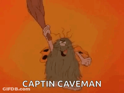 A Cartoon Caveman With A Beard Is Holding A Bat And Saying `` Captin Caveman '' . GIF