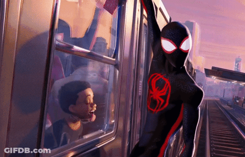 A Cartoon Character In A Black And Red Suit With A Red Spider On His Chest Is Standing Next To A Train GIF