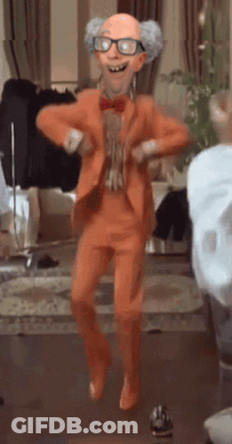 A Cartoon Character In An Orange Suit Is Dancing In A Room GIF