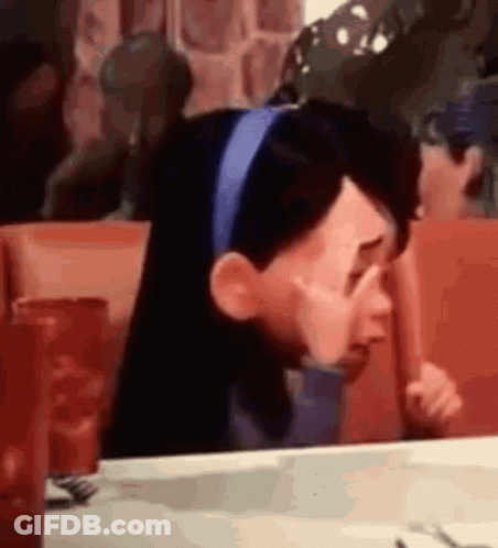 A Cartoon Character Is Crying While Sitting At A Table In A Restaurant . GIF