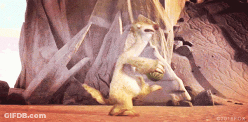 A Cartoon Character Is Holding A Ball In Front Of A Large Rock . GIF
