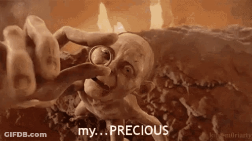 A Cartoon Character Is Holding A Ring In His Hand And Says `` My ... Precious '' . GIF