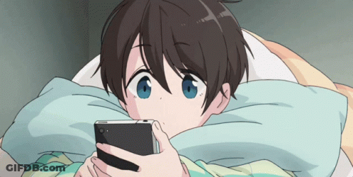 A Cartoon Character Is Laying In Bed Looking At A Cell Phone GIF