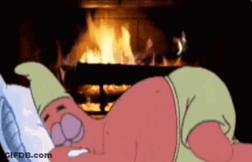 A Cartoon Character Is Laying In Front Of A Fire GIF