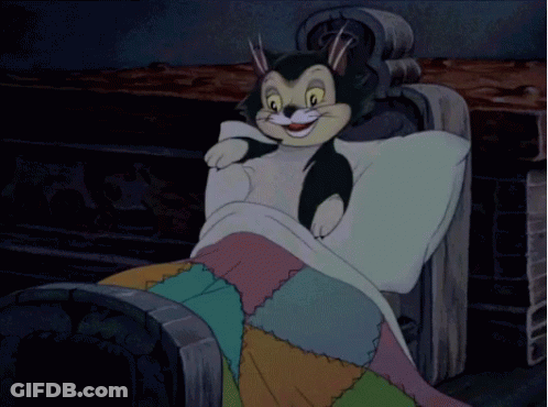 A Cartoon Character Is Laying On A Bed With A Colorful Quilt GIF