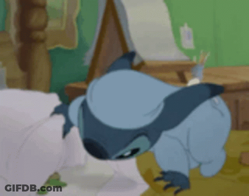 A Cartoon Character Is Laying On A Bed With His Head On The Floor GIF