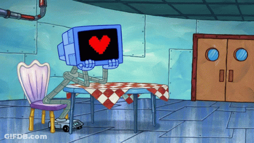 Cartoon Character Sitting At Table With Heart On Monitor GIF