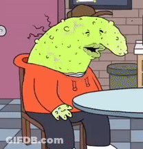 A Cartoon Character Is Sitting At A Table Wearing An Orange Hoodie And Hat GIF