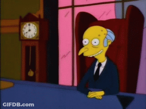 A Cartoon Character Is Sitting At A Table With A Clock Behind Him GIF