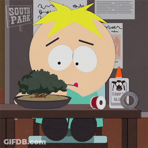 A Cartoon Character Is Sitting At A Table With A Sign That Says South Park In The Background GIF
