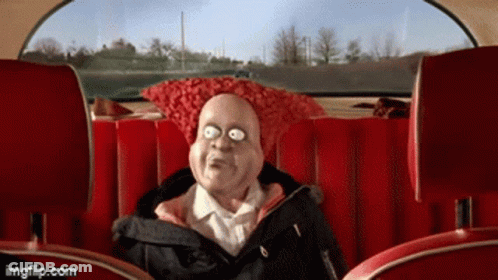 A Cartoon Character Is Sitting In The Back Seat Of A Car With A Red Pillow On His Head GIF