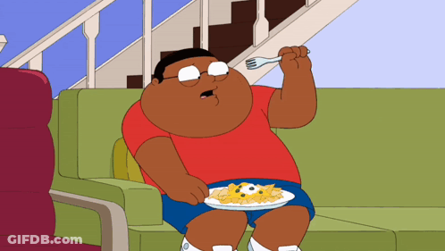 A Cartoon Character Is Sitting On A Couch Eating A Plate Of Food GIF