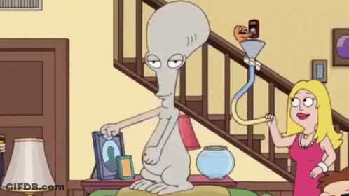 A Cartoon Character Is Sitting On A Couch In A Living Room Next To A Staircase . GIF
