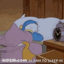 A Cartoon Character Is Sleeping In A Bed With An Alarm Clock Next To It . GIF