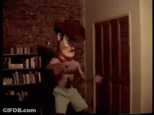 A Cartoon Character Is Standing In A Room With A Brick Wall . GIF